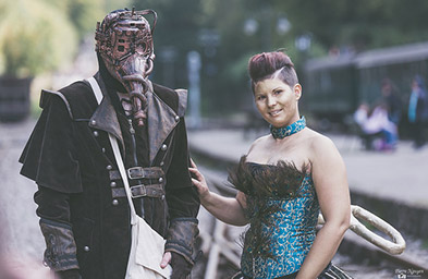 Picture of two people, one wearing a steampunk-inspired mask, posing for a photo