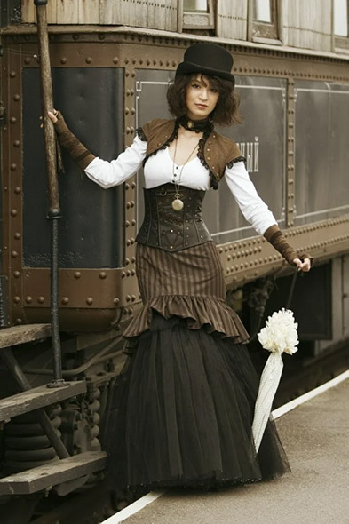 Picture of a woman wearing a Victorian corset posing in front of a train